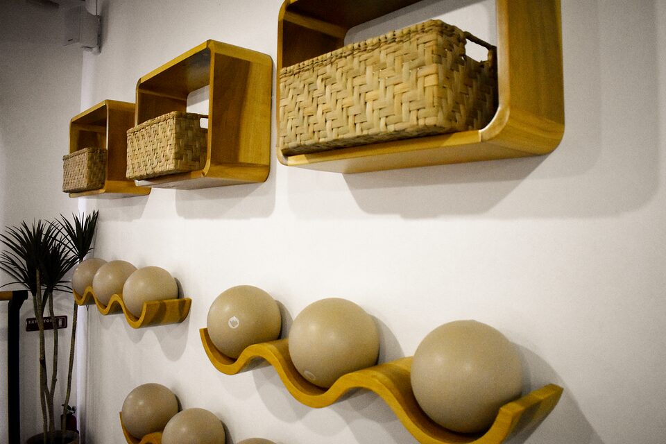 Detalle del muro con pelotas de pilates y canastas